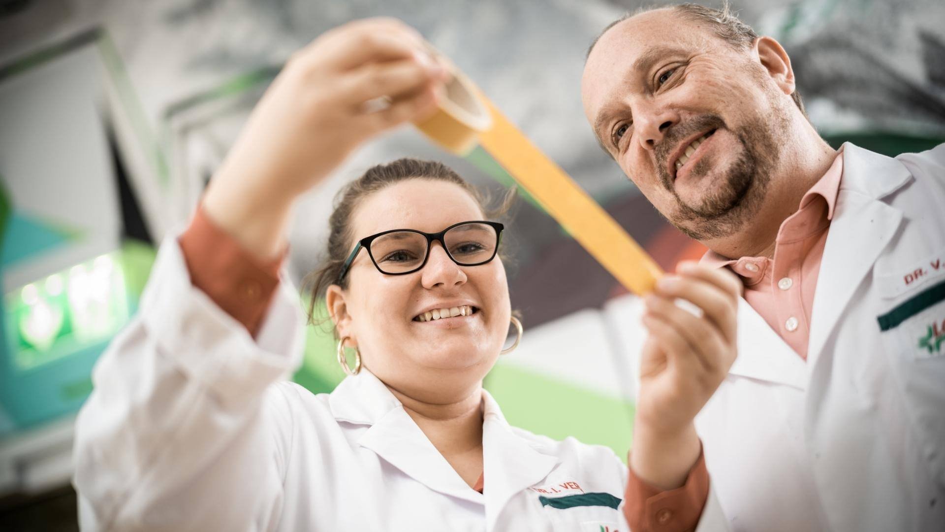 Lohmann-two-people-looking-at-tape-in-their-hands-smiling