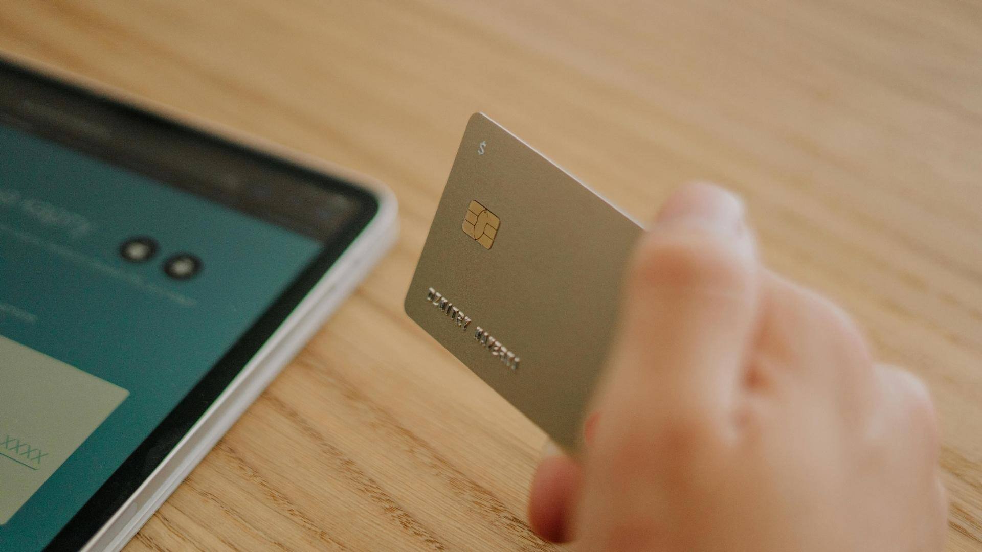 Smart-cards-hand-with-credit-card-tablet-in background