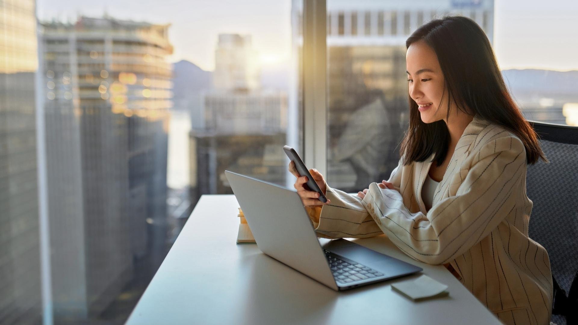 Consumer-electronics-chinese-woman-with-notebook-and-smartphone-in-front-of-skyscraper-right