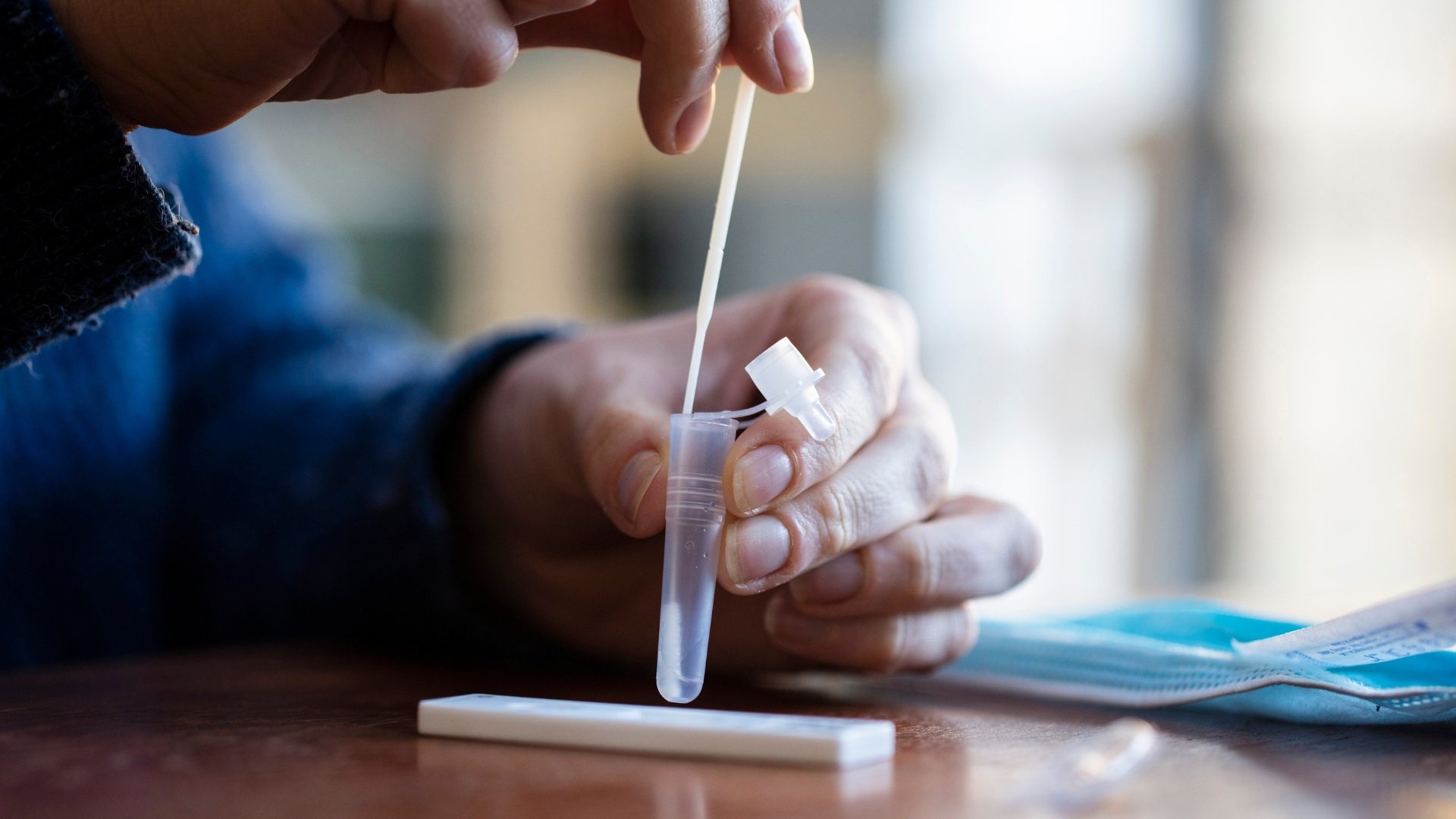 Close-up-person-using-lateral-flow-covid-antigen-test-kit