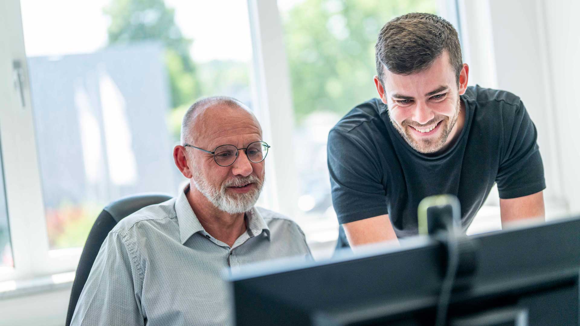 Employees-old-and-young-conversation-at-desk